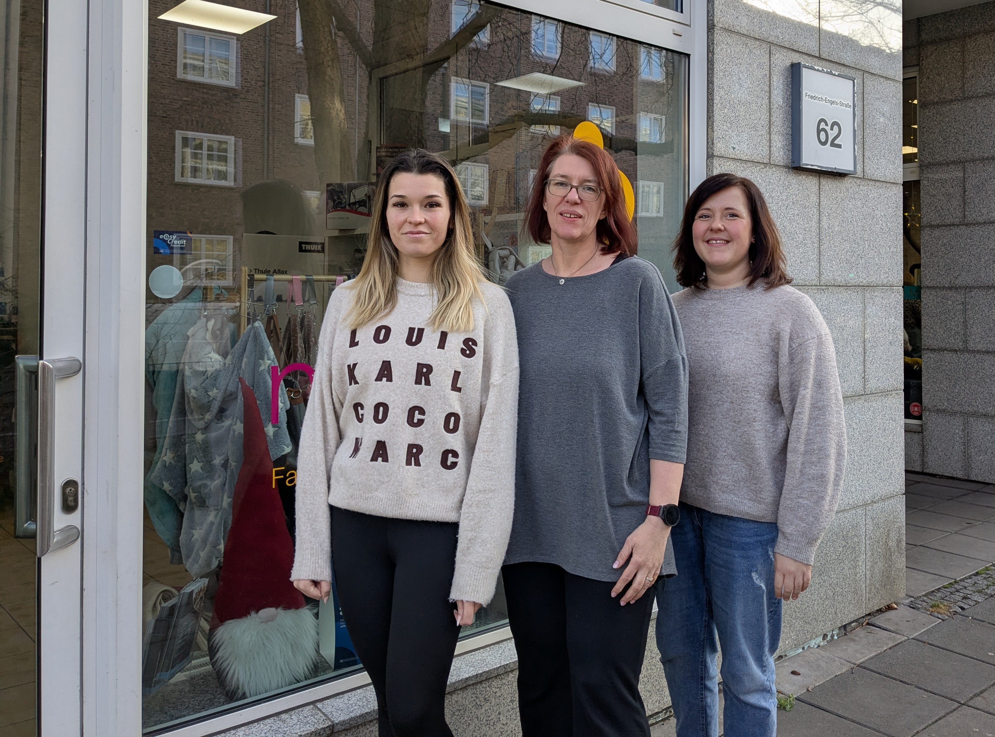 Drei Frauen stehen vor einem Ladengeschäft