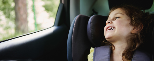 Kind im Kindersitz im Auto schaut aus Fenster Kind im Kindersitz im Auto schaut aus Fenster