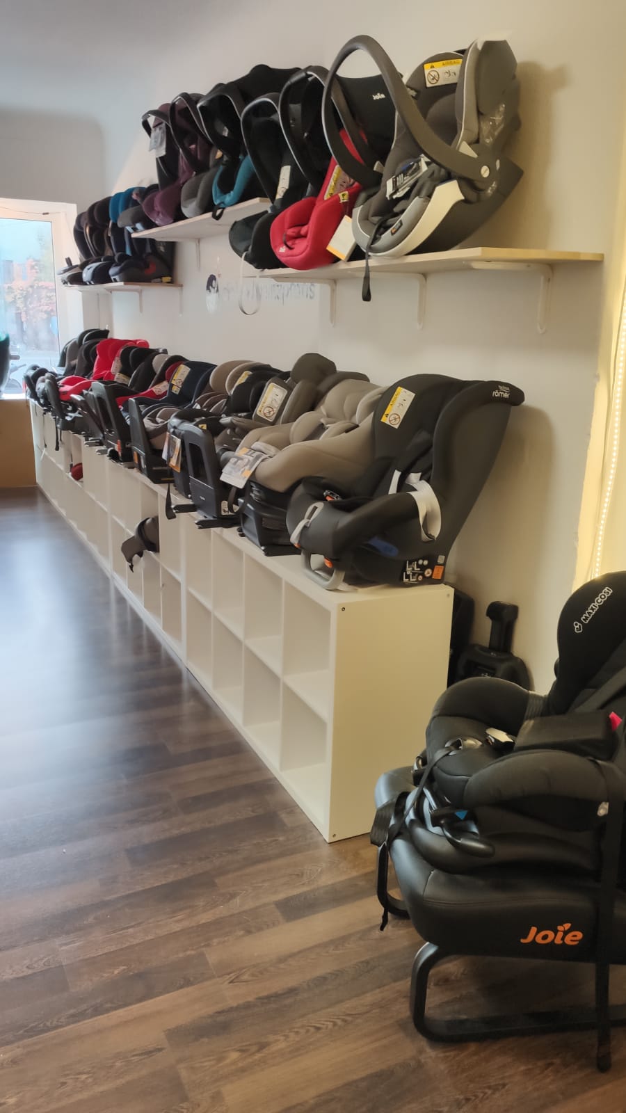 Wand mit ausgestellten Kindersitzen Wand mit ausgestellten Kindersitzen