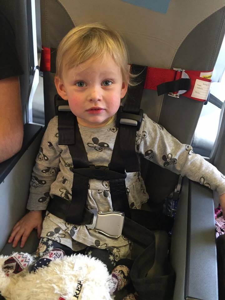 Fliegen mit Kleinkind Kind in Cars Gurt im Flugzeugsitz