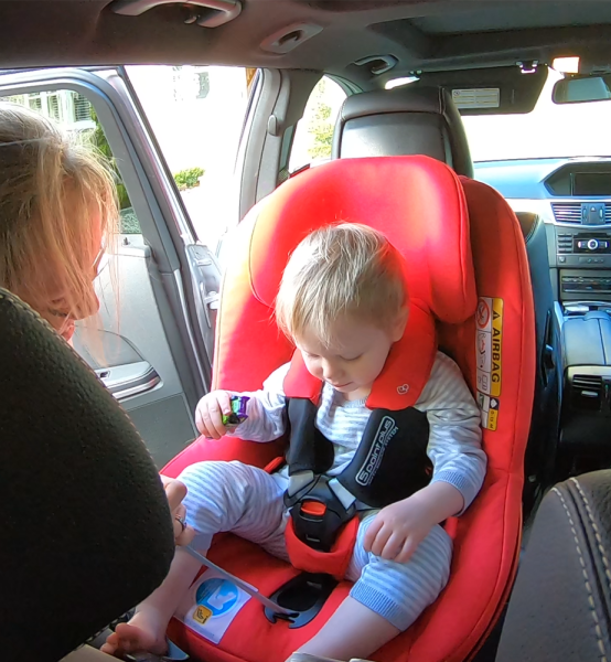 Kind wird im Kindersitz mit 5-Point-Plus System angeschnallt Kind wird im Kindersitz mit 5-Point-Plus System angeschnallt